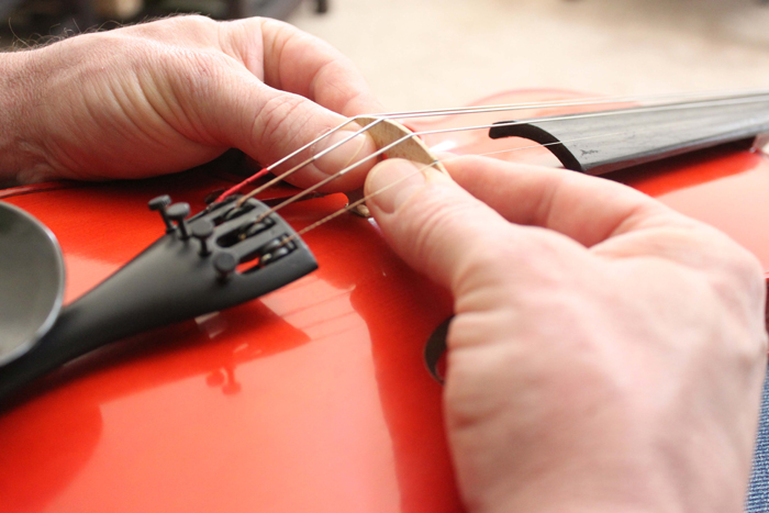 image showing how to adjust the top of a violin bridge to be perpendicular with the violin body top